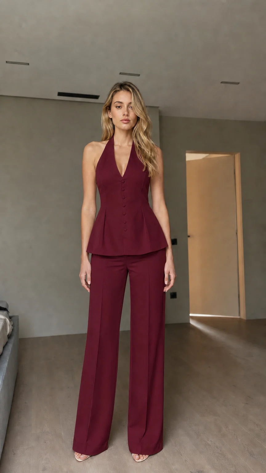Model wearing burgundy halter peplum vest and wide-leg pants set