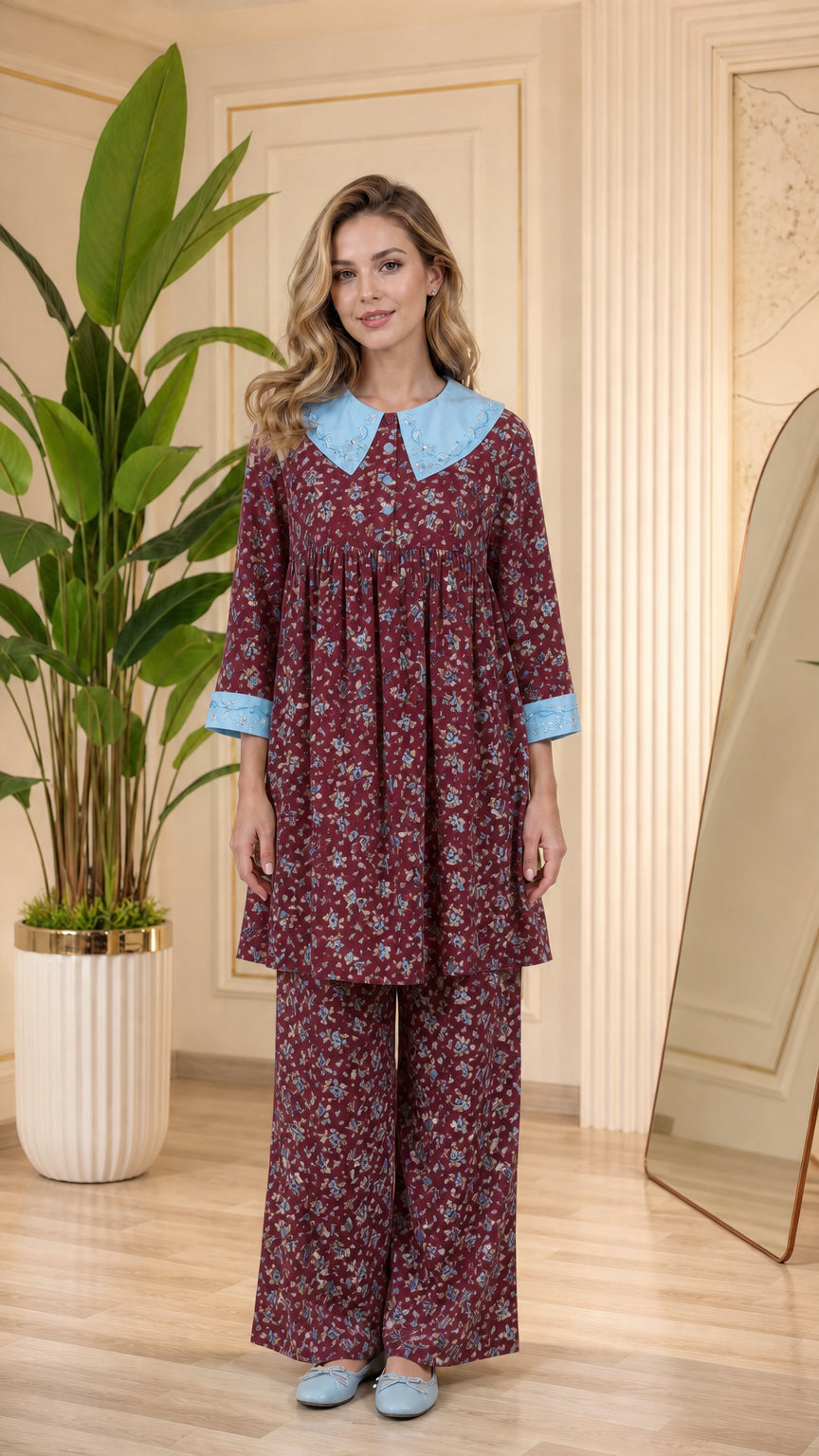 Model wearing burgundy floral pajama set with light blue contrast collar and cuffs