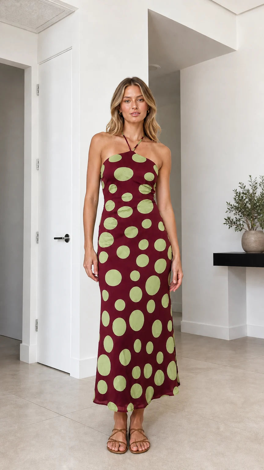 Model wearing burgundy polka dot halter midi dress