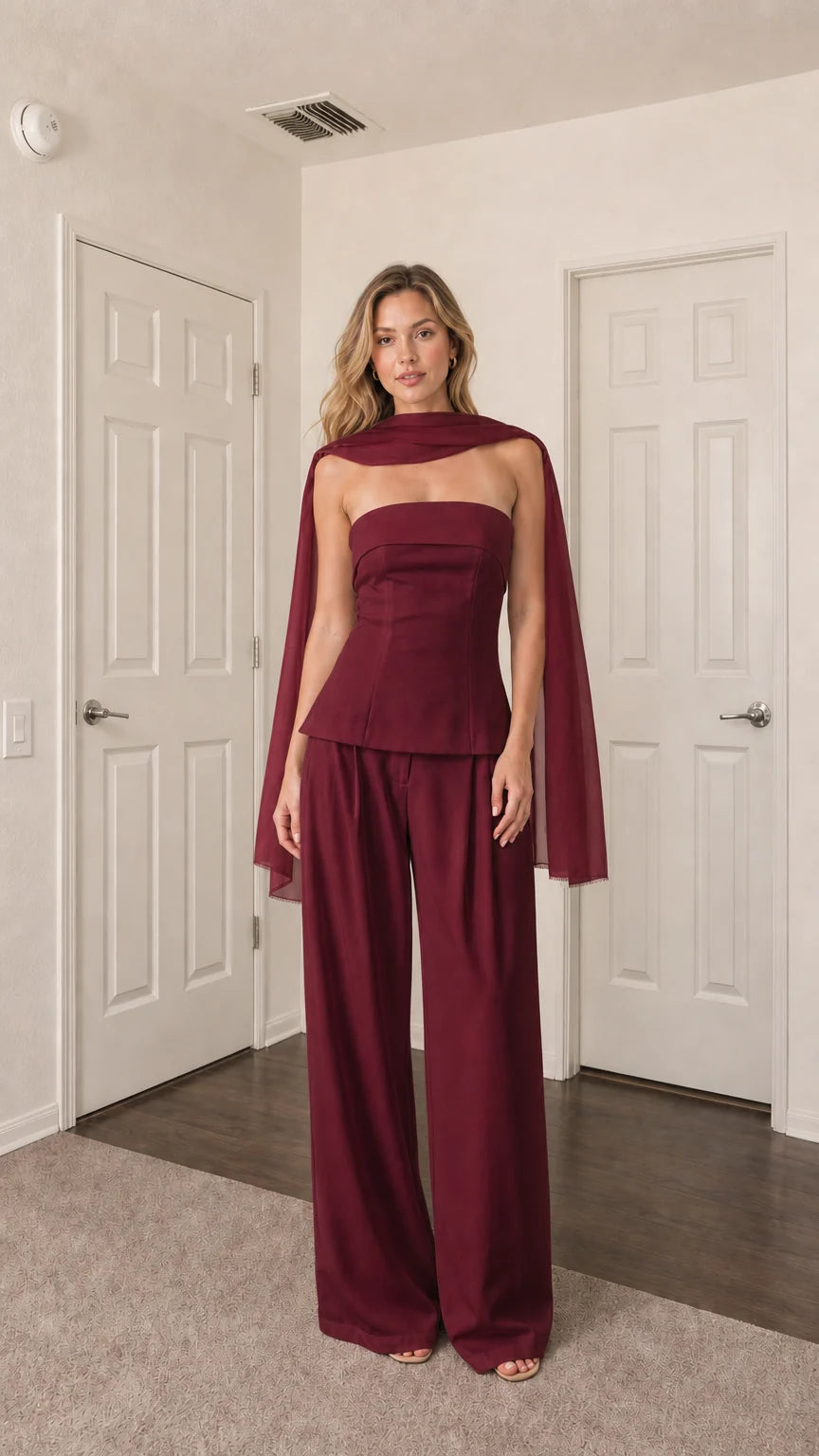 Front view of model wearing burgundy strapless top, wide-leg pants, and scarf