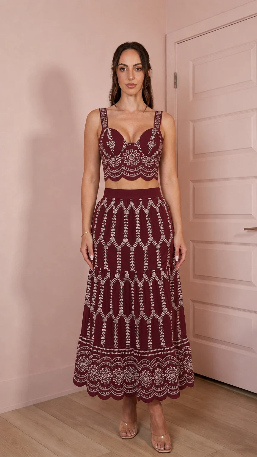 Model wearing burgundy two-piece embroidered crop top and skirt set