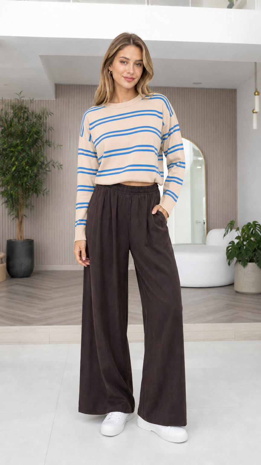 Model wearing beige and blue striped cropped knit sweater with dark wide-leg pants