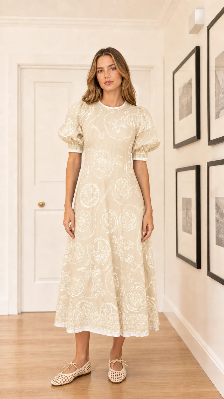Woman wearing cream colored embroidered puff sleeve midi dress